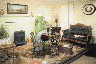 Featured is a postcard image of a c 1880 sewing room (at the Maine State Museum) full of sewing collectibles:  sewing machine, patterns, notions, sewing table, buttons, sewing bird, etc.  (Actually, it's a mirrored reflection of a room...hence the line down the middle of the image!)  The original unused postcard is for sale in The unltd.com Store. 